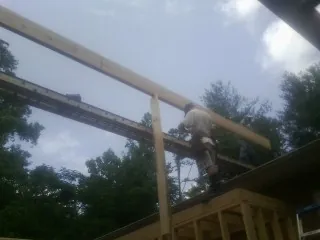 Carpenter setting a ridge beam over a new addition frame — Ice Dam Removal by Roofing Brothers in Cherry Valley