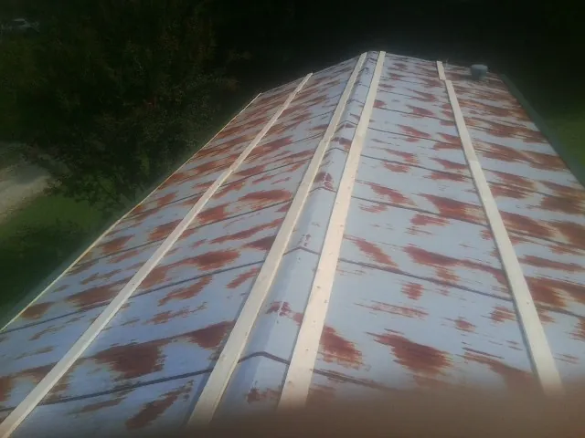 Rusted metal roof panels with new wood purlins before replacement — Storm Damage Roof Repair in Cherry Valley by Roofing Brothers