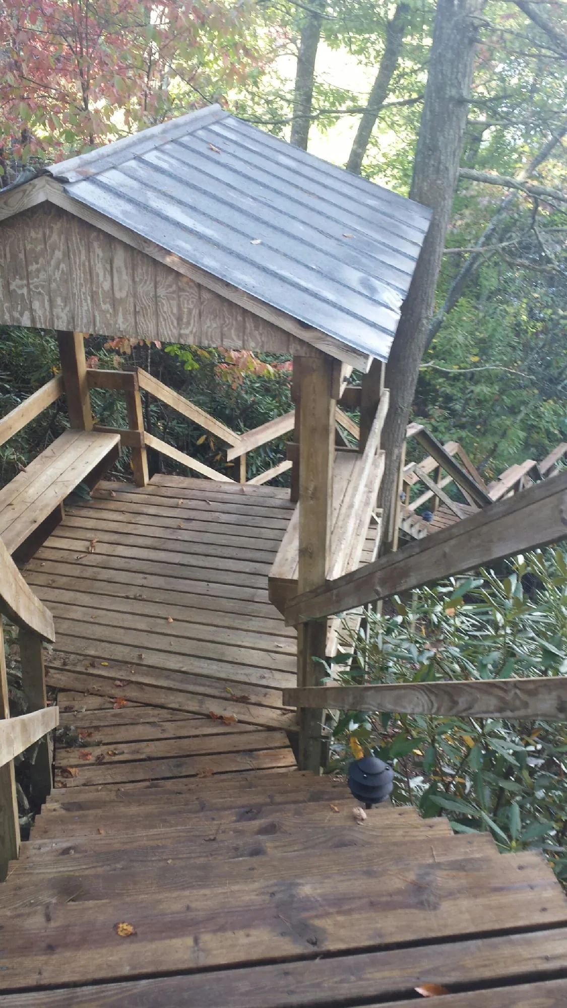 Metal roofed shelter over wooden steps on a wooded walkway — Skylight Repair & Installation work by our crew in Cherry Valley